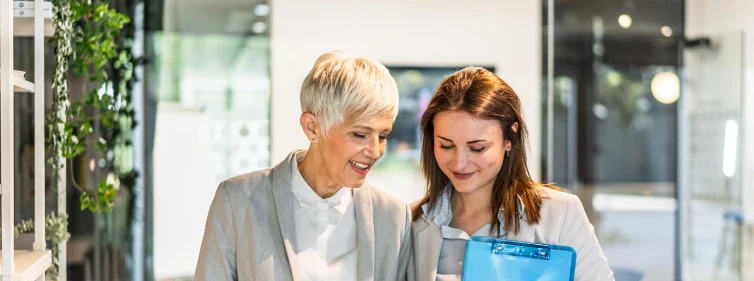 An experienced colleague guiding a new employee at the office
