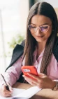 Young professional reviewing notes on her phone