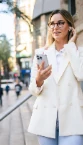 Young professional on the move in the city, phone to her ear
